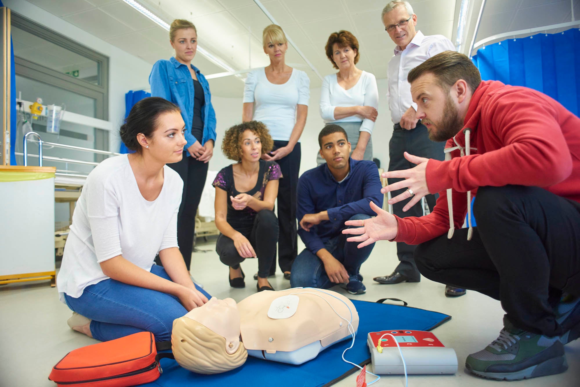 Instructor demonstrating to a group how to perform CPR