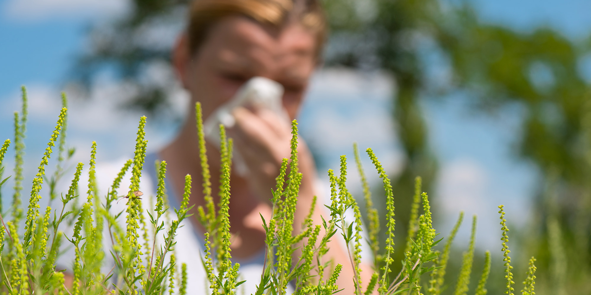 image of a woman blowing her nose outside