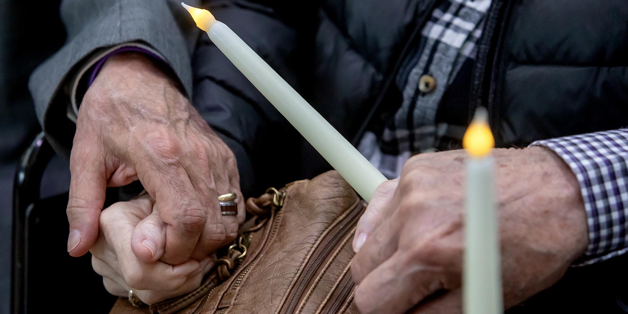 People holding hands with a candle lit