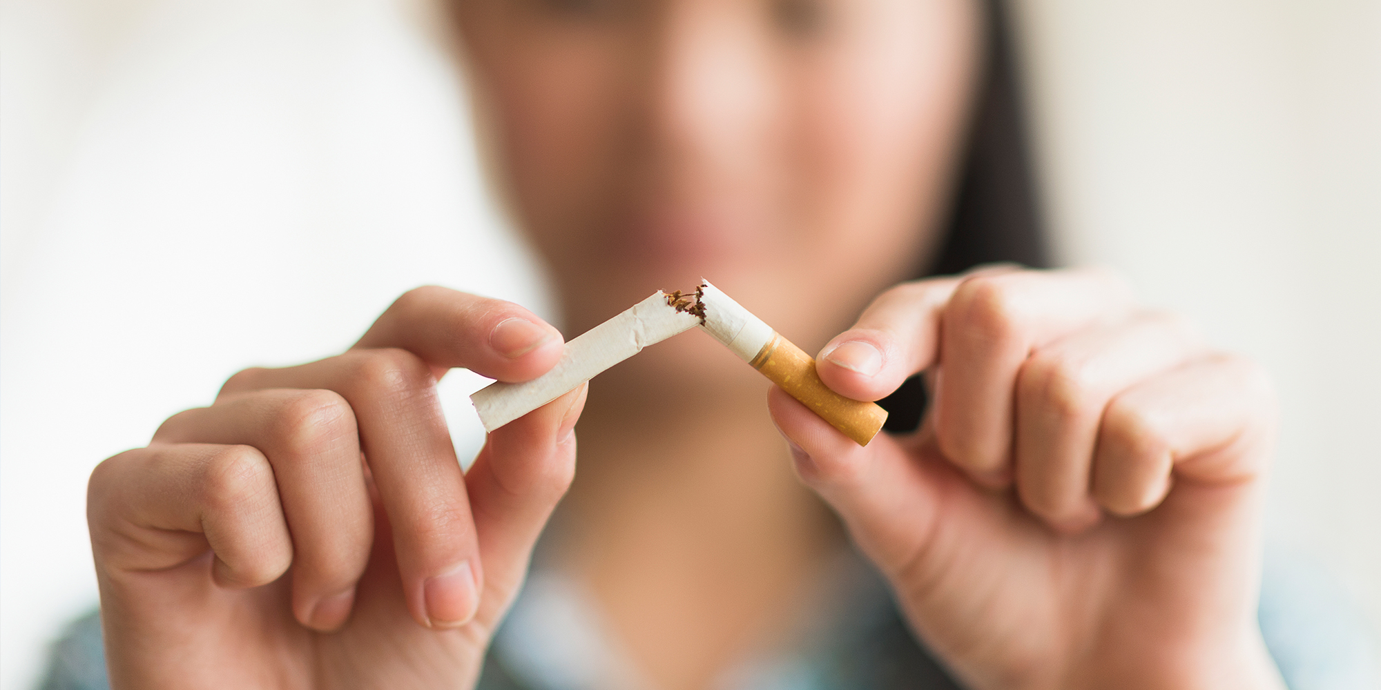 Woman snapping cigarette in two