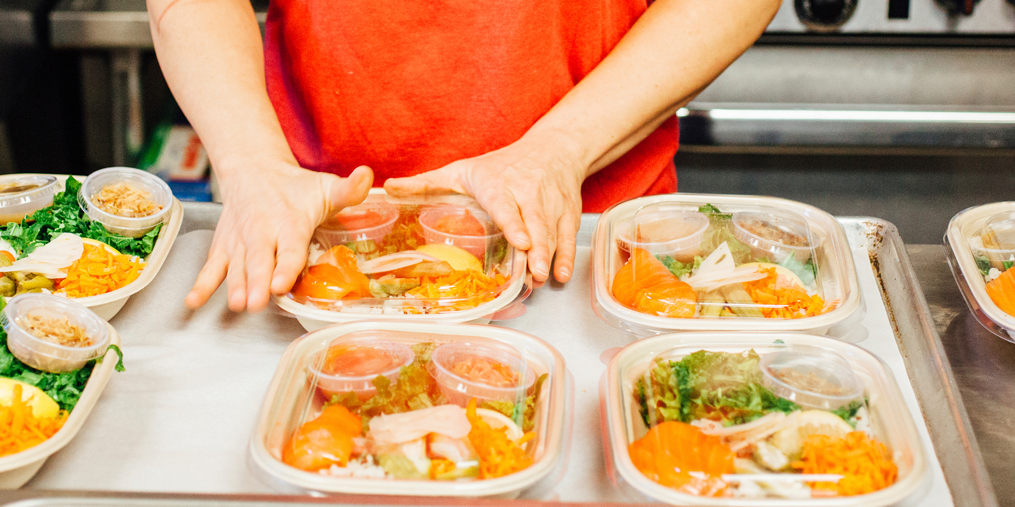 Photo of woman packing food in food container